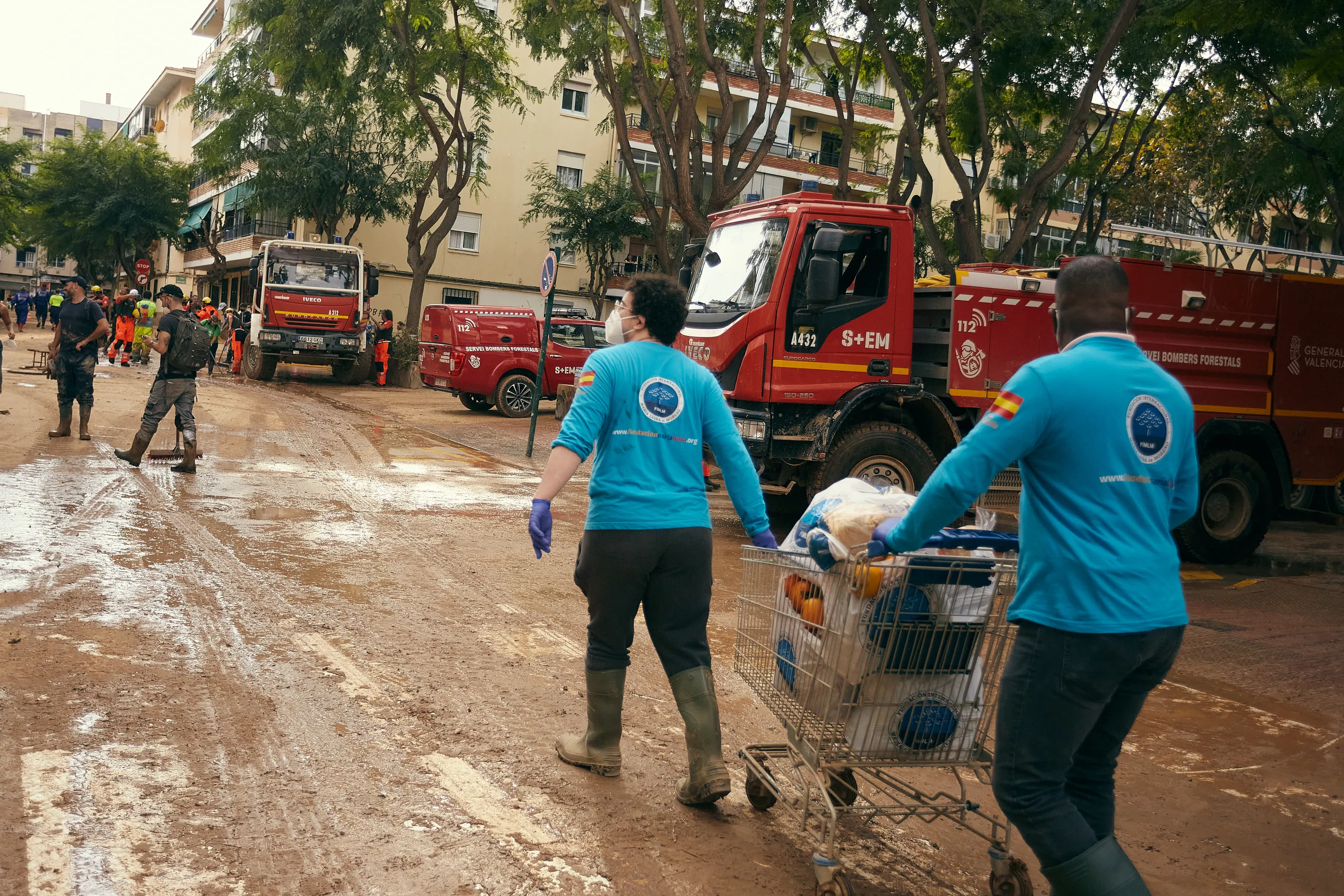 Voluntarios de la Fundación caminando con ayuda humanitaria por una calle afectada por la DANA en Valencia